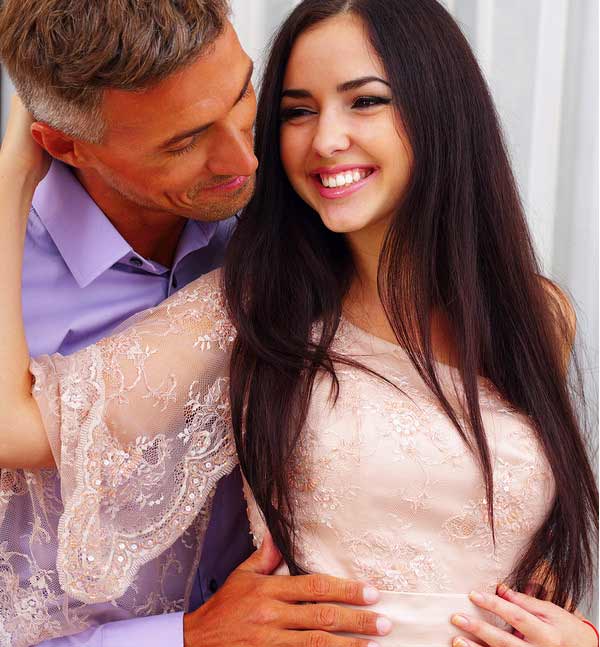 A sugar daddy hugs his sugar baby with sweet smile